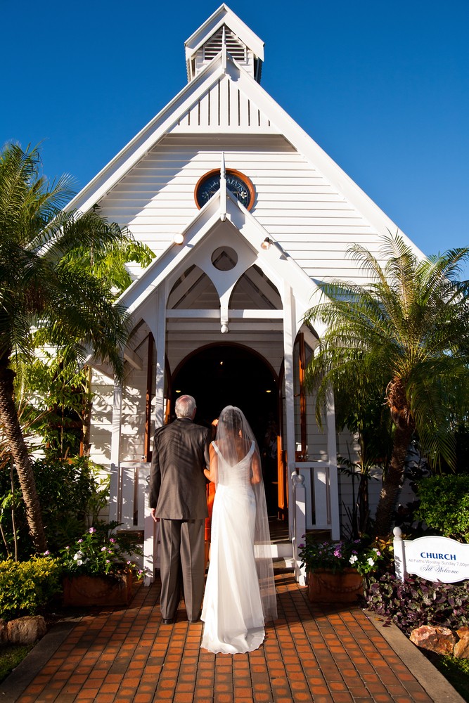 Pai e filha entrando na igreja para celebrar casamento.