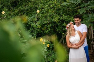 Casal tirando fotos em um campo com flores.