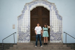 Casal posando para foto em frente casarão. 