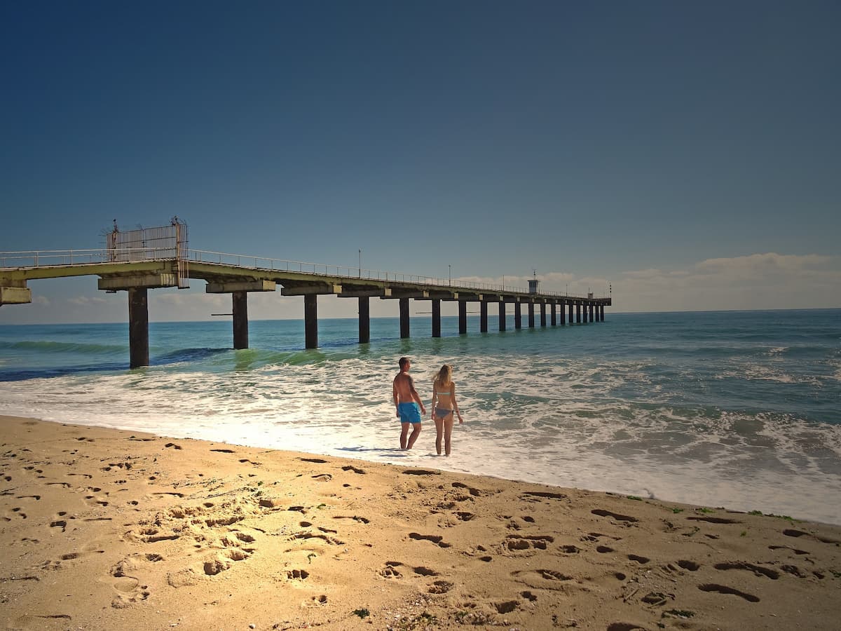 Imagem de uma praia paradisíaca com duas pessoas na água