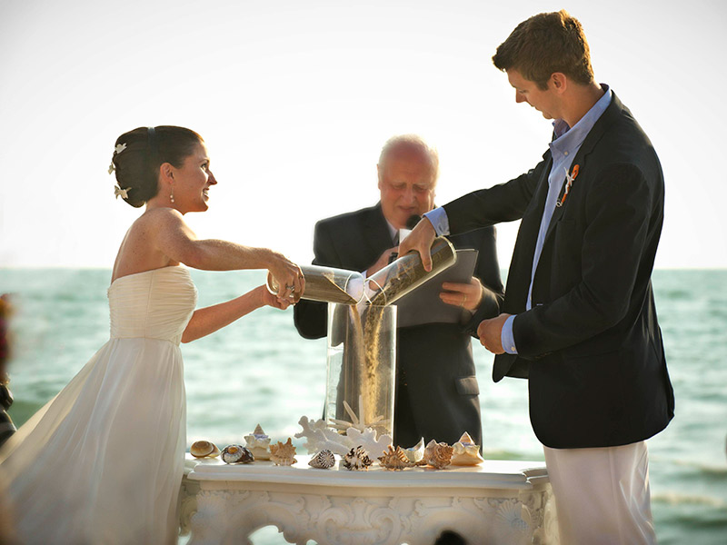 Cerimônia de casamento noivos celebrando com areia
