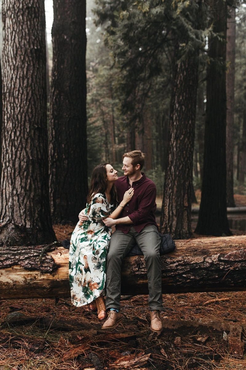 Casal comemorando os 5 anos de casamento em uma floresta, em tema com as bodas de madeira
