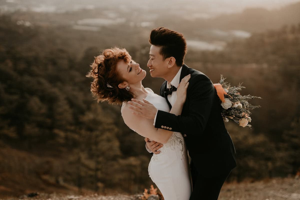 Imagem de um casal de noivos no alto de um penhasco