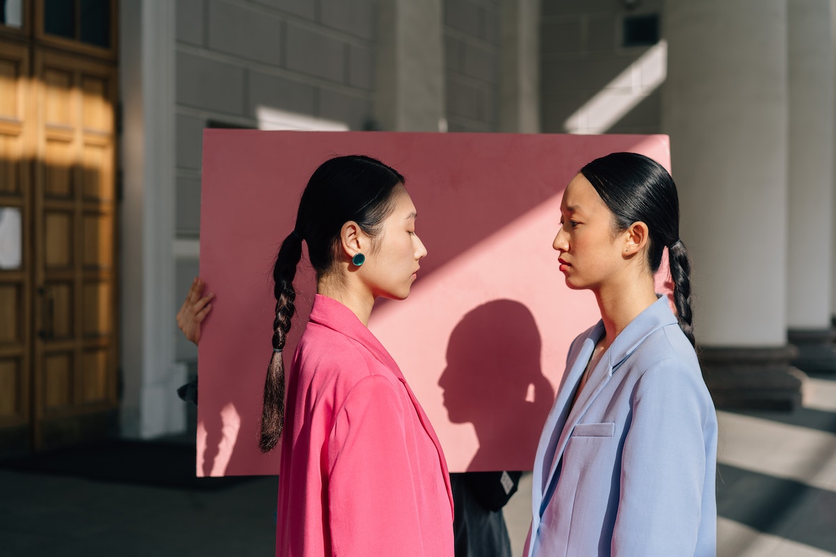 Duas mulheres vestido rosa e azul se olhando para uma foto