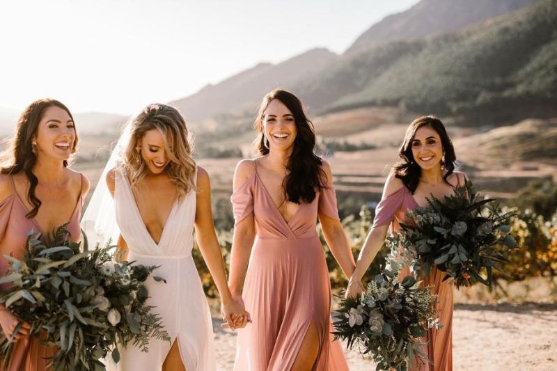 Noiva com as amigas andando de mãos dadas 