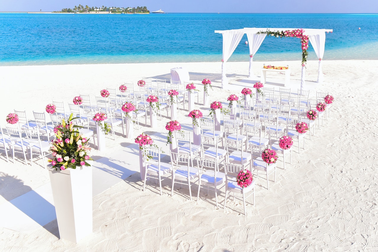 Decoração de casamento na praia com flores rosas nas cadeiras