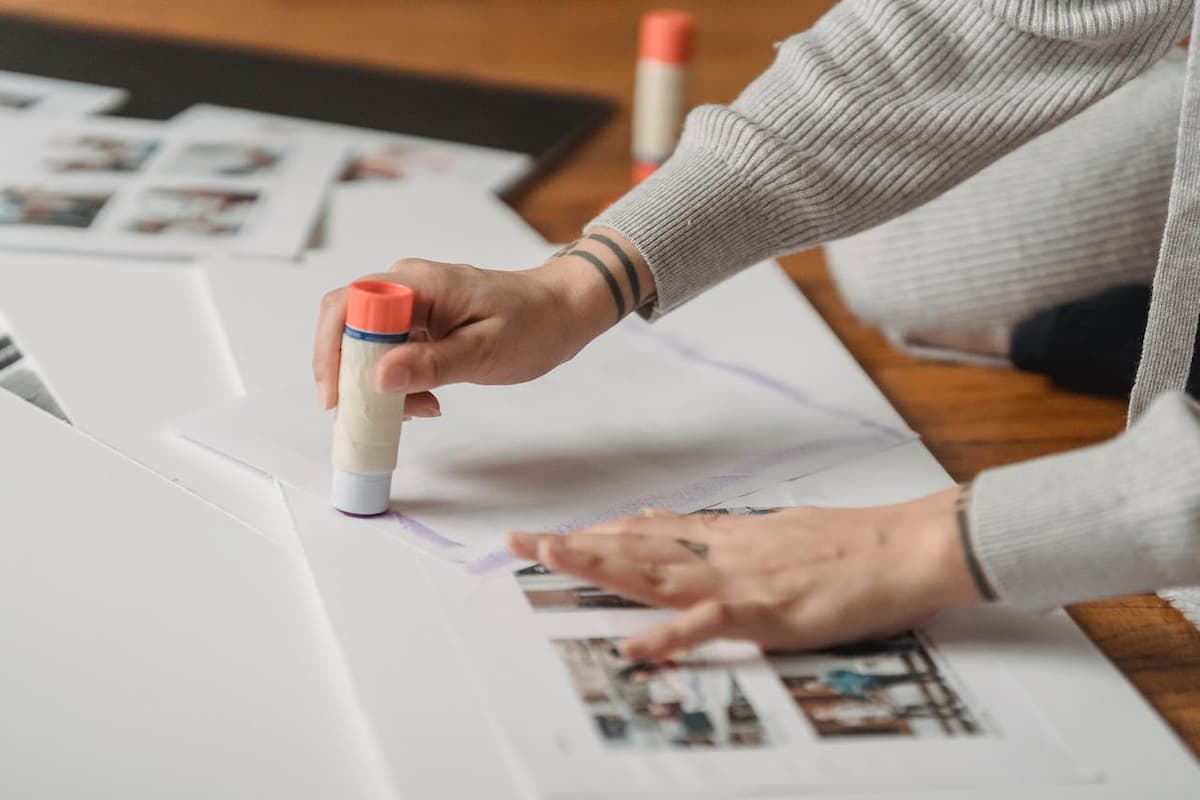 Imagem de uma pessoa colando fotos em um papel branco