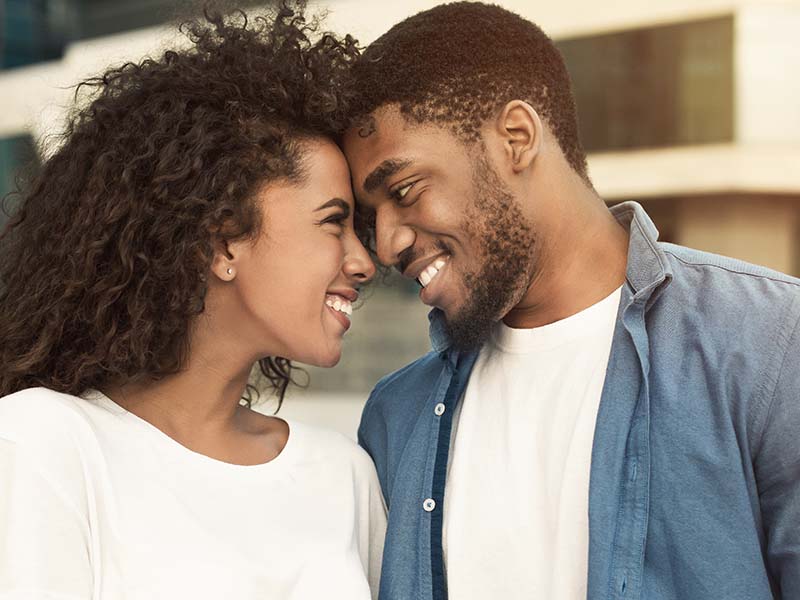 Tender couple touching foreheads, bonding to each other, walking in city