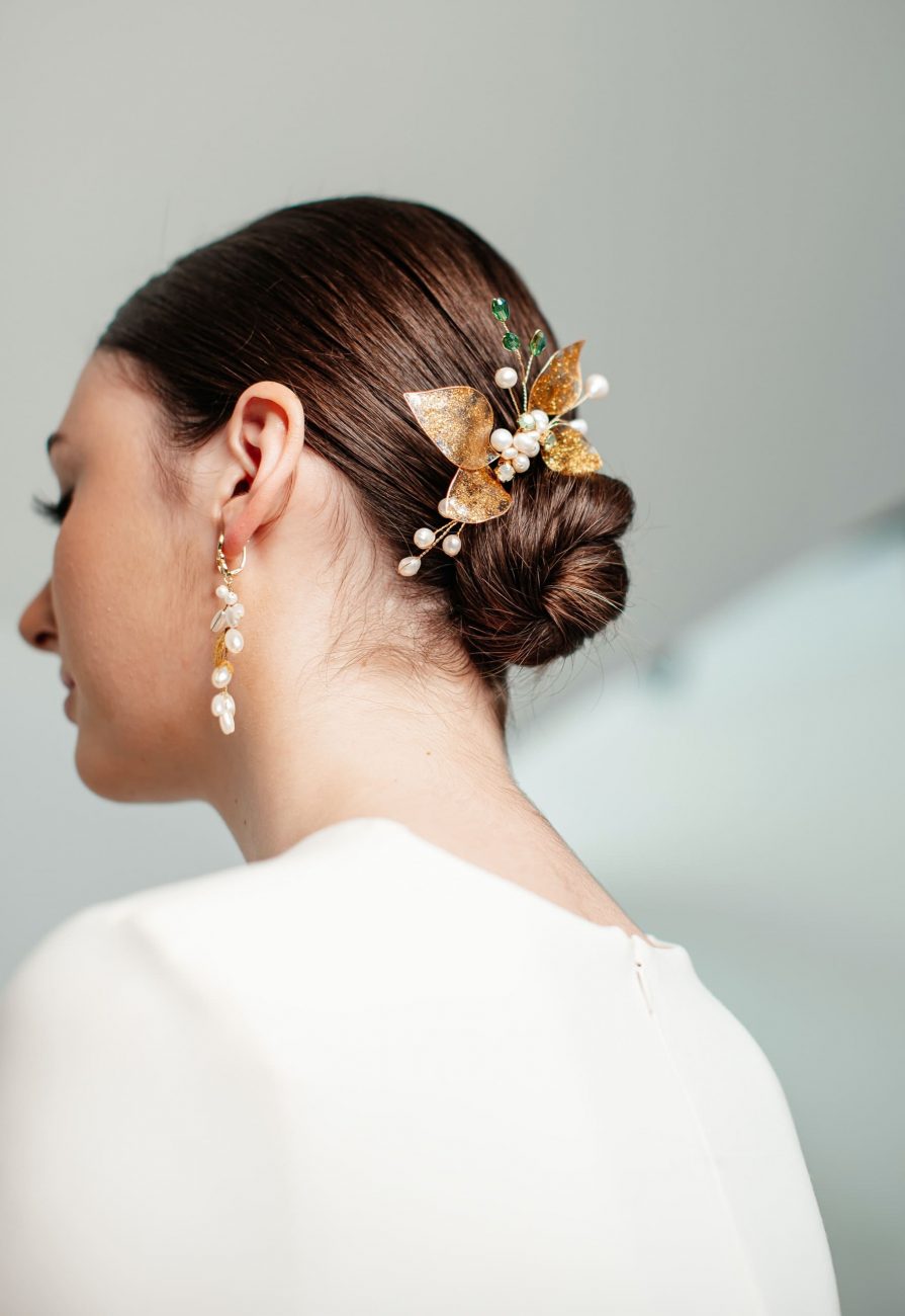 Noiva, vestida de branco, com um coque no cabelo. Imagem disponível em Pexels.
