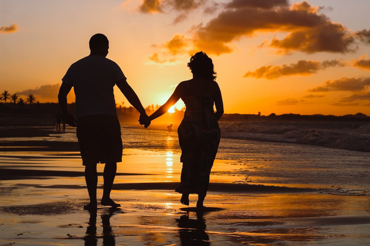 Casal na praia em um pôr do sol