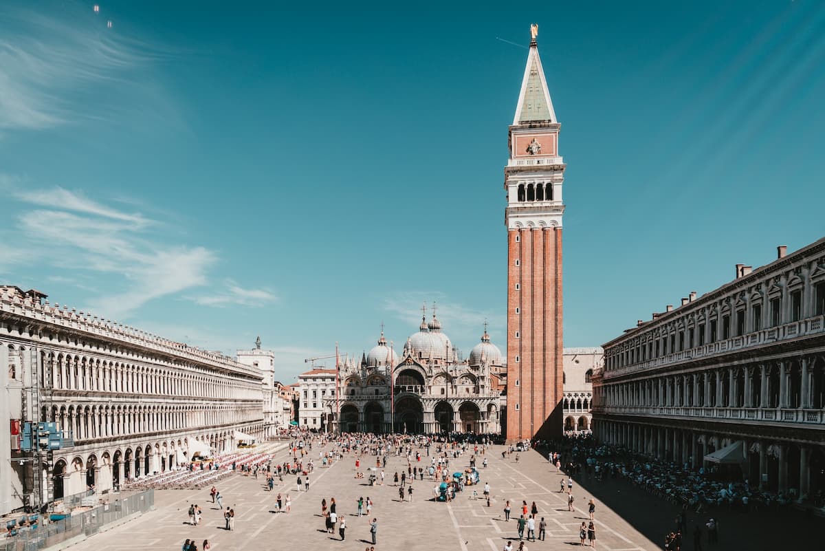Pessoas andando durante o dia em um grande espaço em Veneza