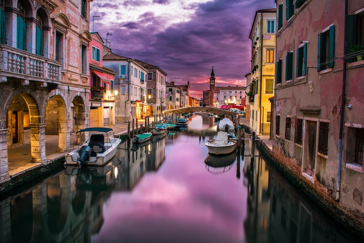 Imagem de barcos no grande canal de Veneza no pôr do sol