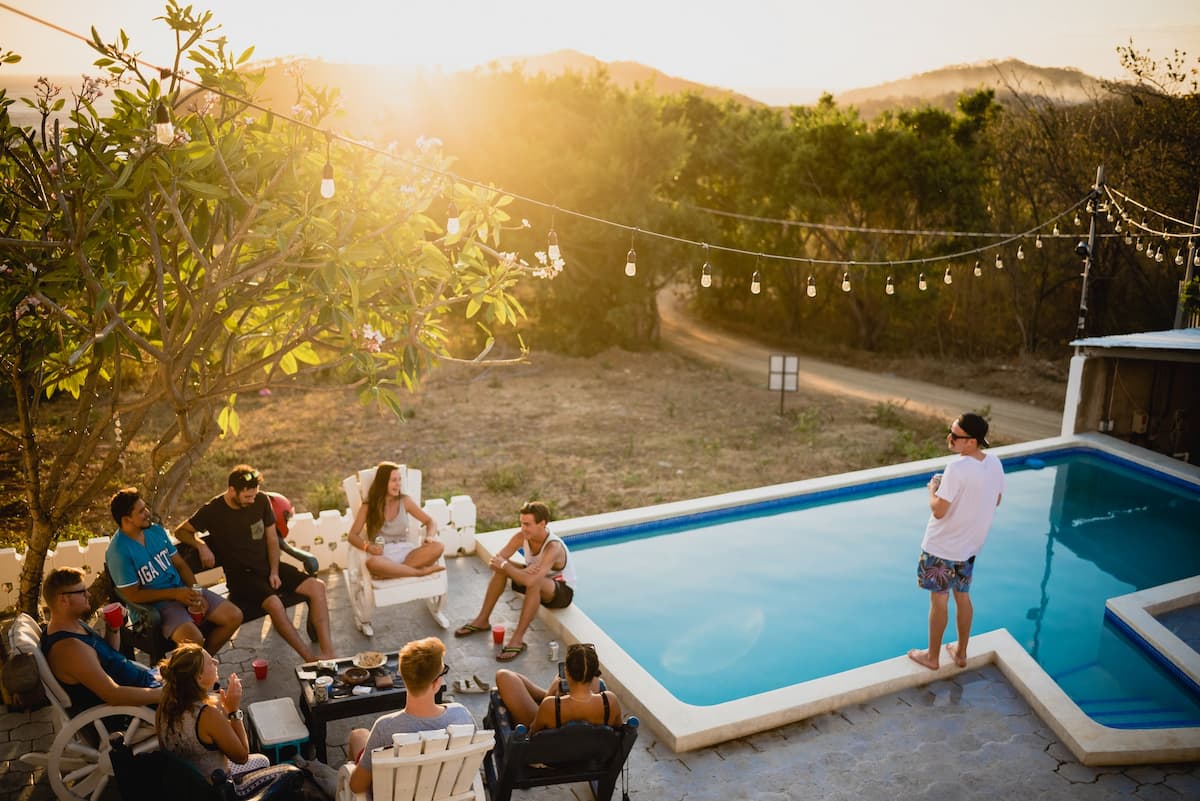 Amigos do lado da piscina bebendo e se divertindo