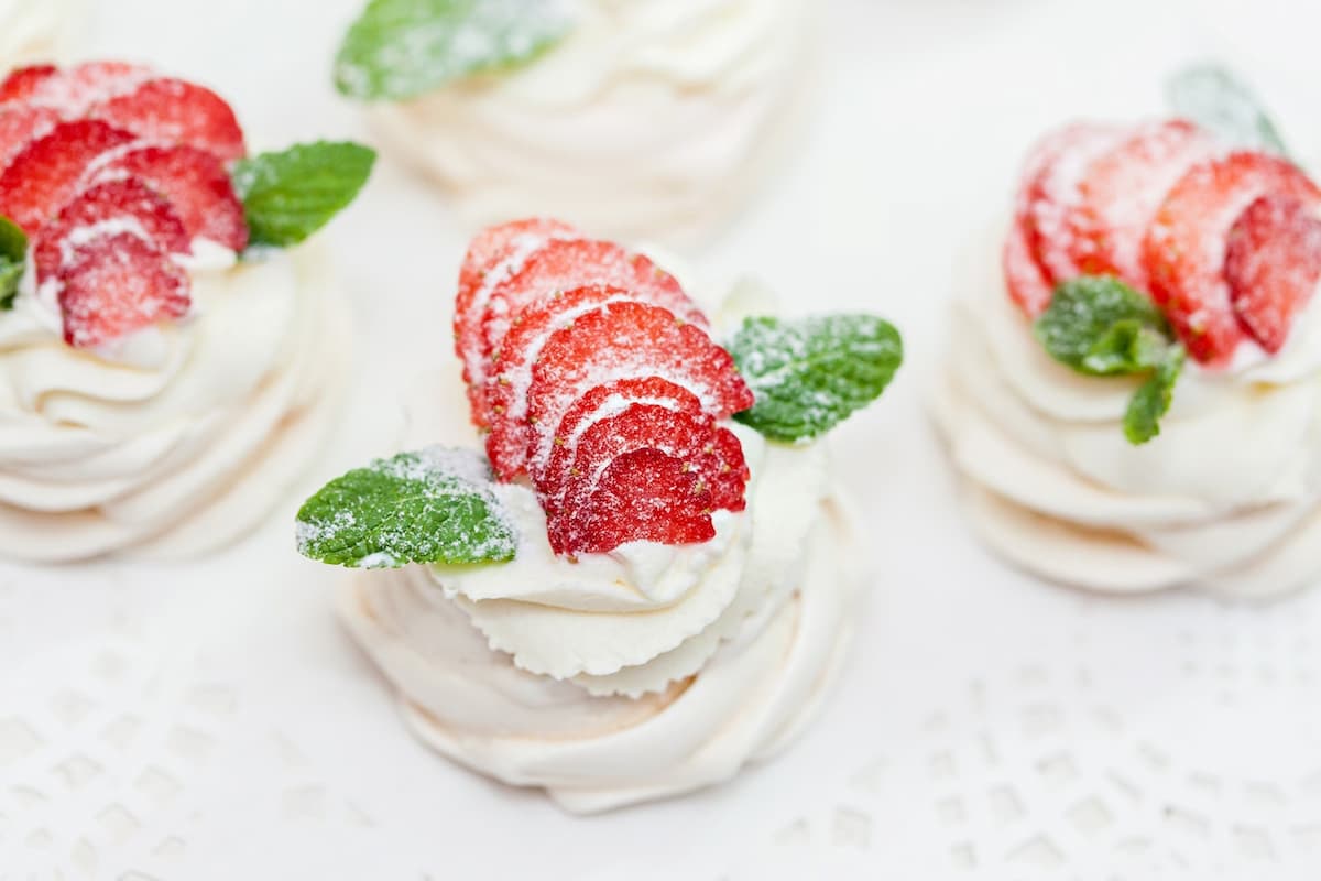 Imagem de uma sobremesa de creme branco com morangos