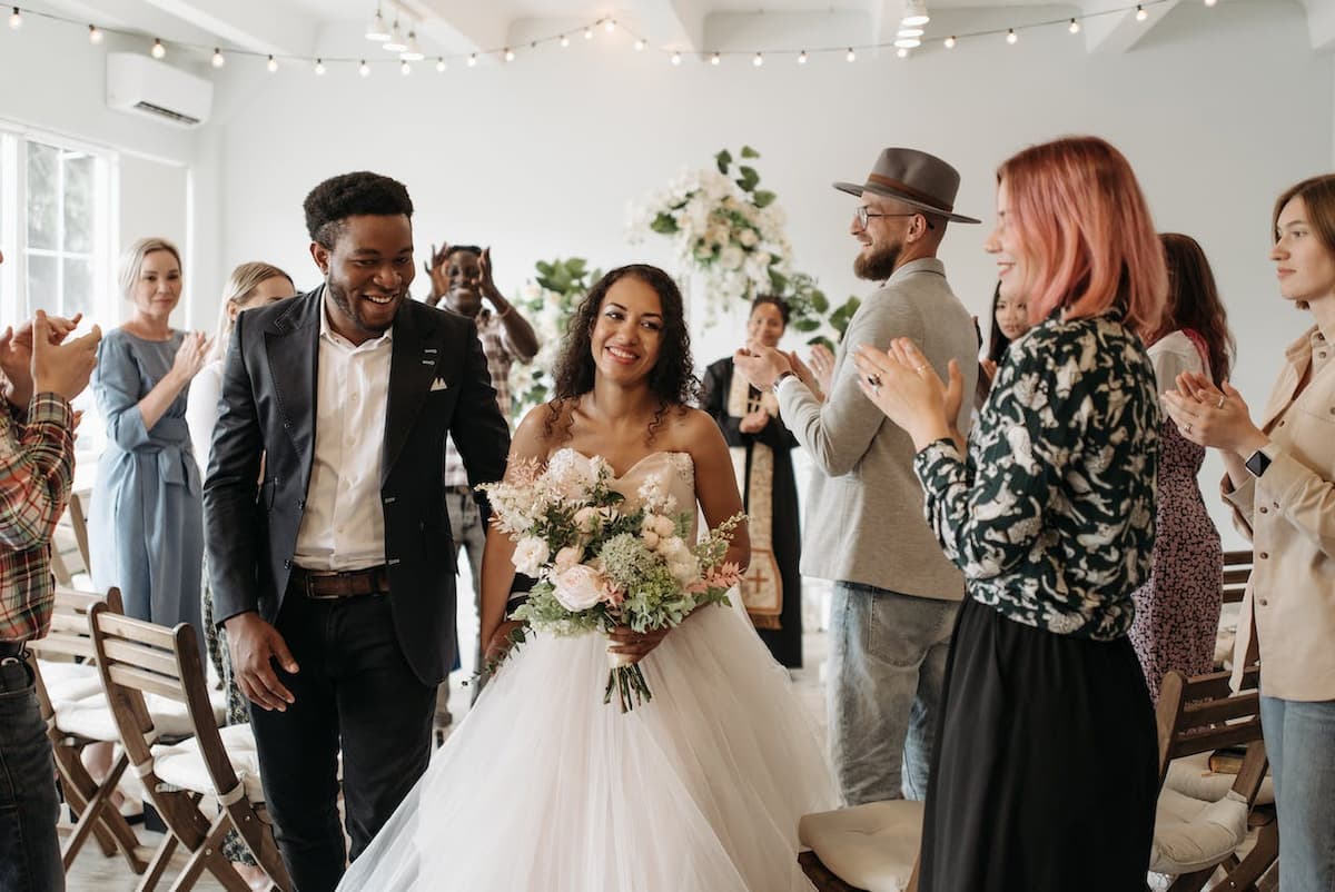 Imagem de um casamento com os noivos no meio do corredor