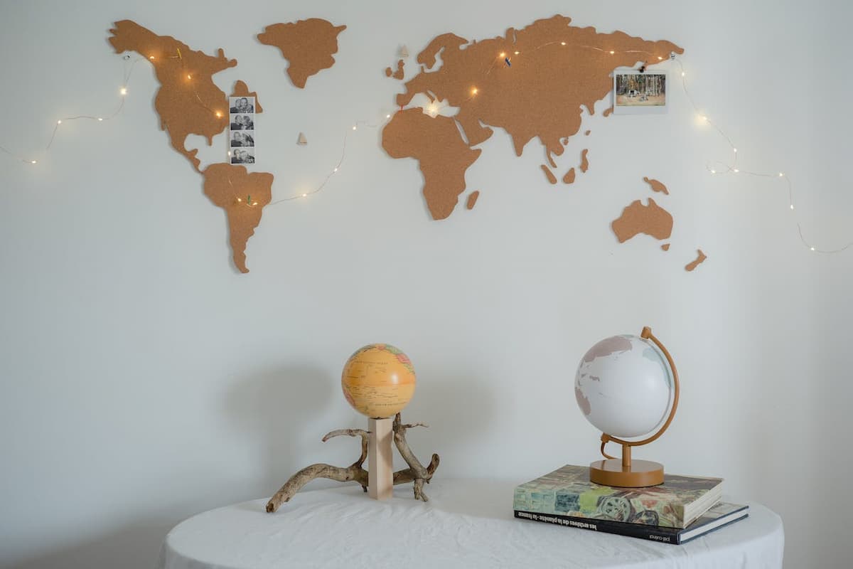 Imagem de uma mesa e parede branca com itens de decoração de viagem