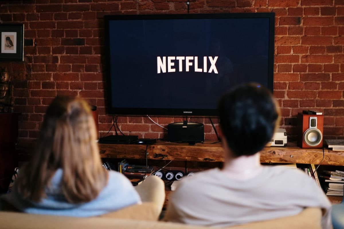 Casal assistindo a Netflix sentados no sofá