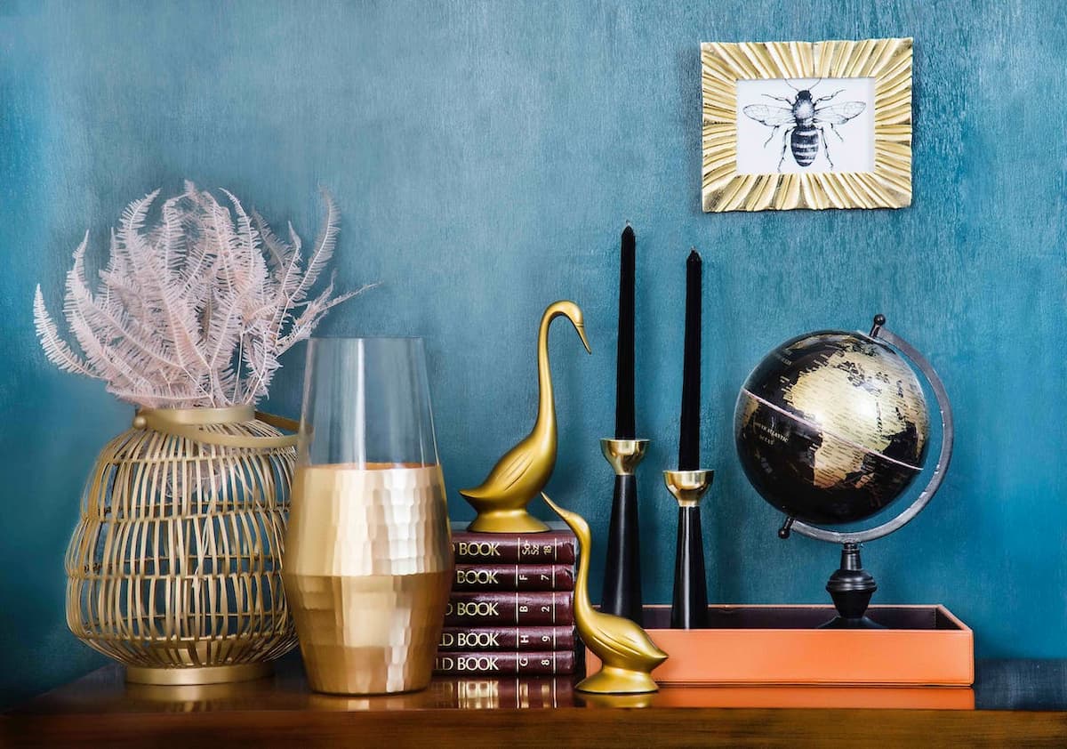 Parede azul de uma casa com itens de decoração em uma mesa de madeira