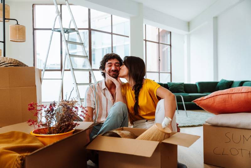 Casal jovem feliz com caixas de mudança em um novo apartamento