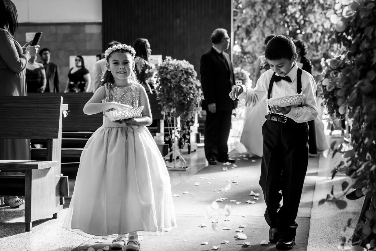 Pajem e daminha jogando pétalas na engtrada do casamento.