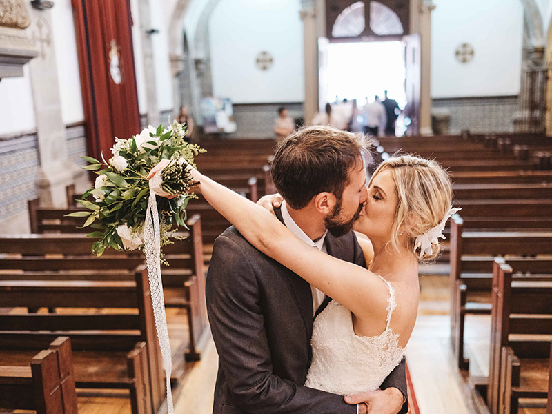 Casamento em Portugal final da cerimônia noivos se beijando na igreja