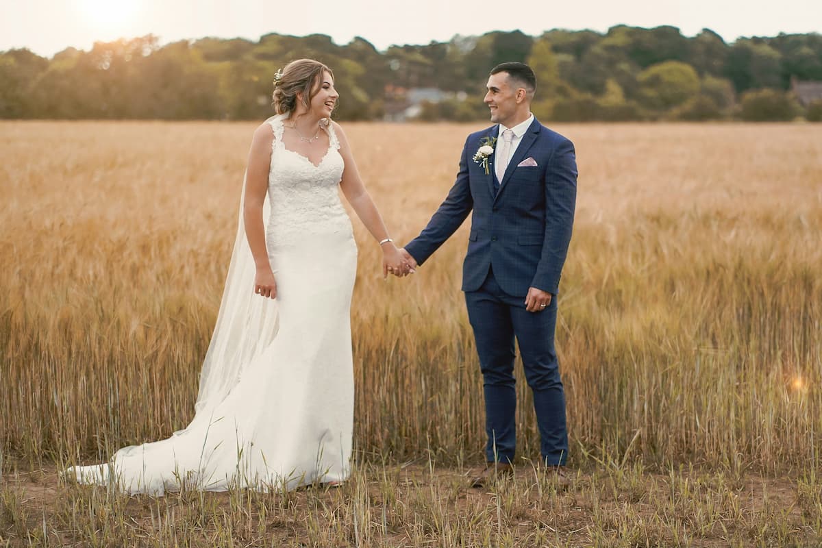 Casal de noivos em foto no campo de casamento no sítio.||